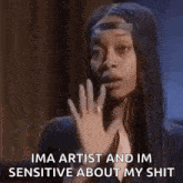 a woman with long black hair is waving her hand and says `` ima artist and im sensitive about my shit '' .
