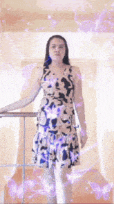 a woman in a dress is standing on a staircase with purple butterflies around her