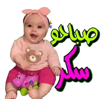 a baby wearing a pink shirt with a teddy bear on it sits next to a pink hippo