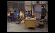 a group of people are sitting around a desk in a classroom ..