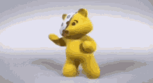 a yellow teddy bear with a face cut in half is dancing .