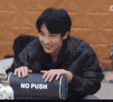a man is holding a no push sign