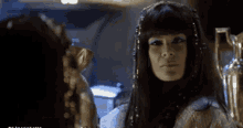 a woman in a costume looks at herself in the mirror
