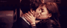 a man and woman are kissing in front of a sign that says honeymoon
