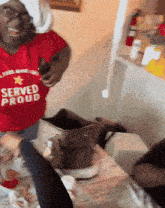 a woman wearing a red shirt that says " served proud "
