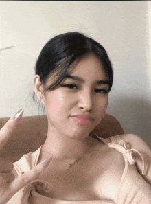 a woman sitting on a couch making a peace sign