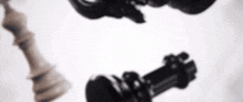 a blurry picture of a king and queen chess piece on a white background