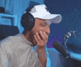 a man wearing headphones is laughing in front of a microphone .
