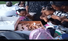 a little girl is eating cupcakes from a box
