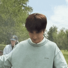 a man wearing a light blue sweatshirt with the word age pure on it