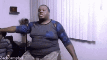 a man is dancing in a living room with the name zachcampbel written on the bottom