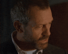 a man with a beard and a white shirt looks at the camera