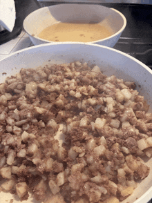 a white pan filled with meat and potatoes next to a white pan filled with liquid