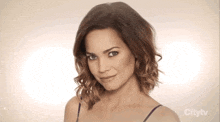 a woman 's face is shown in a city tv ad