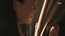 a close up of a woman 's face with a max logo behind her