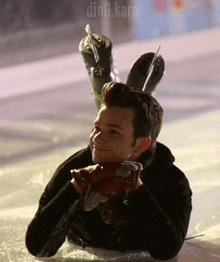 a man is laying on the ice wearing ice skates on his head