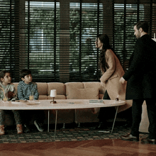 a family sitting on a couch with a table in front of them