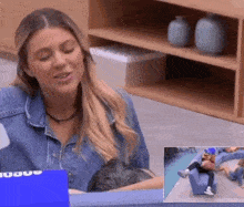 a woman in a denim shirt is sitting in a chair holding a baby .