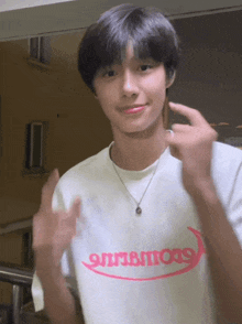 a young man wearing a white t-shirt that says ' 911bm999 ' on it