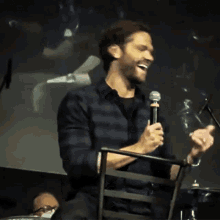 a man in a plaid shirt is holding a microphone