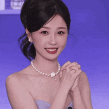 a woman wearing a pearl necklace and earrings is smiling