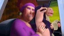 a woman in a purple dress is holding a stuffed animal in her arms