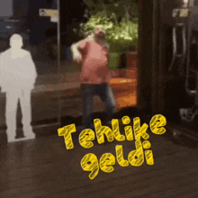 a man is dancing in front of a sign that says telike geldi