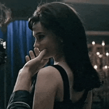 a man is touching a woman 's face with his hand in a dark room .