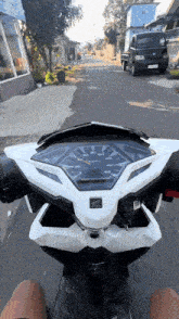 a person is riding a honda scooter down a road