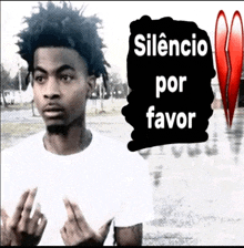 a man giving the middle finger with the words silencio por favor behind him