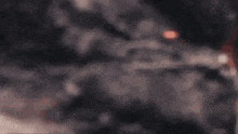 a blurred image of a person standing in front of a mountain with a red light coming out of it .