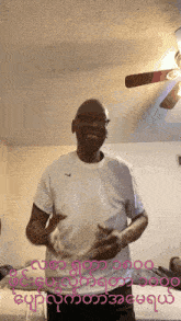 a man in a white nike shirt is dancing in a bedroom