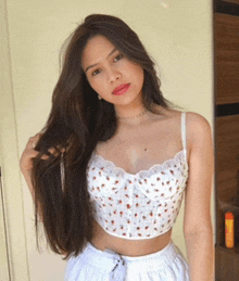 a woman wearing a white crop top and white shorts