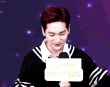 a man with red hair is holding a microphone and a sign that says paopao