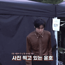 two men are standing in front of a black tent with a sign that says ' a3 ' on it