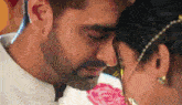 a man and a woman are touching their noses and looking at each other .