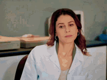 a woman in a white lab coat is sitting in a chair