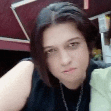 a woman is taking a selfie with her eyes closed and making a funny face .