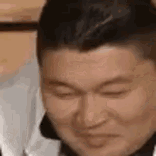 a man with his eyes closed is making a funny face .