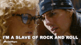 a man and a woman are looking at each other and the man is saying i 'm a slave of rock and roll