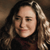 a woman with a red scarf around her neck smiles