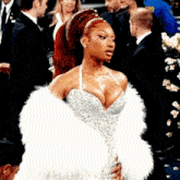 a woman in a dress and fur coat is standing in a crowd .