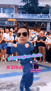 a man wearing sunglasses and a blue suit is dancing in front of a crowd and captioned #sikat