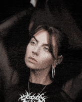 a woman with a nose ring and a necklace that says ' skeletons ' on it