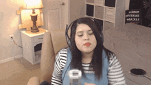 a woman wearing headphones is sitting in front of a nightstand with a sign that says " i love you " on it