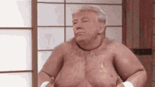 a shirtless man is standing in front of a window with his hands on his stomach .