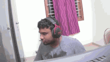 a man wearing headphones is sitting in front of a computer