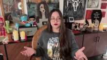 a woman wearing a shirt that says welcome to schlitz is sitting in a chair