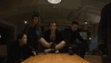 a group of people are sitting around a table with their legs crossed