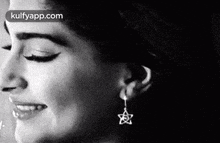 a close up of a woman 's face wearing earrings .